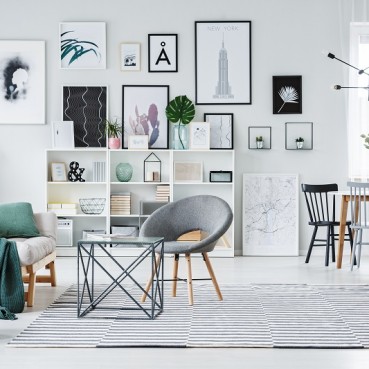 Salon w stylu skandynawskim z galerią grafik
